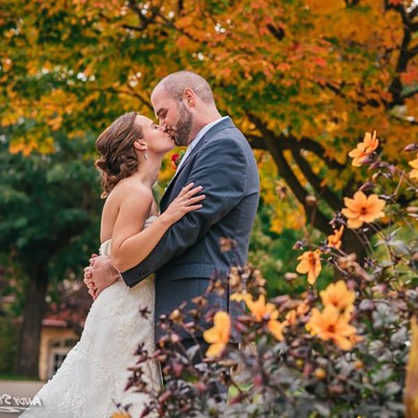 Picture of a couple kissing, dressed up in their wedding attire, celebrating their wedding day at Carroll University. 